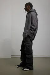 Pantalón cargo negro de corte recto, con múltiples bolsillos con cierre y botón.