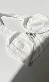 Top blanco de lino con escote halter y espalda descubierta. Se ata al cuello y a la espalda con tiras finas.