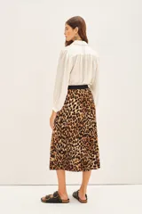 Falda larga plisada con estampado de leopardo, cintura elástica negra y caída fluida.