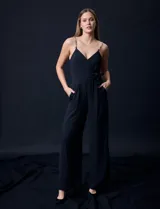 Enterito celeste de crepe marca Luxology, con escote en V cruzado, cintura elastizada, espalda en punto smock y tirantes con detalle de cadenas.