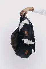 Riñonera de cuero color negro, marrón y blanco con estampado de vaca.