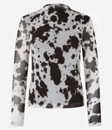 Blusa de mangas largas confeccionada en tule, con cuello alto y estampa animal print de vaca en blanco y negro.