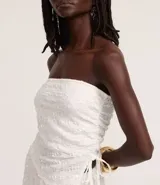 Top sin breteles de lentejuelas color blanco, con escote recto y lazo fruncido en el lateral.