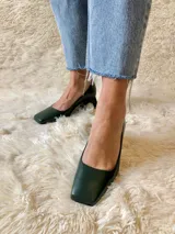 Zapato de cuero verde oscuro con punta cuadrada y tacón geométrico negro. Forro, capellada y plantilla 100% cuero. Tacón de 5 cm.