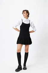 Vestido corto de lurex plateado y negro, sin mangas, con breteles finos regulables y volados tipo balloon desde la cadera.