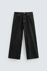 Pantalón de jean negro de corte amplio, con cinco bolsillos, efecto lavado y cierre frontal con cremallera y botón.