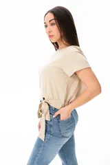 Remera beige de algodón y elastano, con escote redondo y corte a la cintura con lazo lateral.