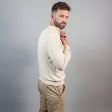 Buzo de punto color azul marino, con cuello alto y medio cierre frontal.