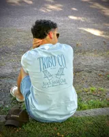 Remera celeste de corte oversized, confeccionada en jersey de algodón. Estampado en la espalda con el logo de la marca, dos reposeras y la frase "Beach Social Club. Girls Just Wanna Have Fun".