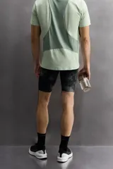 Mallas deportivas cortas de tejido técnico elástico con estampado abstracto en tonos grises.