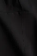 Musculosa negra con breteles anchos, escote cuadrado, cierre lateral oculto, pinzas en el busto y cintura entallada con costuras visibles.