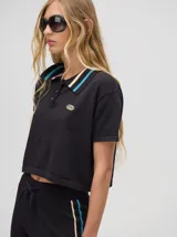 Chomba corta color rojo, con cuello camisero con rayas celestes y negras, logo bordado en el pecho y mangas cortas.