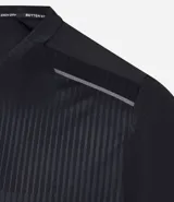 Remera deportiva de manga corta y cuello redondo, color beige claro, con textura acanalada vertical. Presenta detalles reflectantes en los hombros.