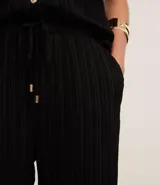 Pantalón recto fluido de chiffon texturizado color negro, con cintura alta, elástico y lazo ajustable.