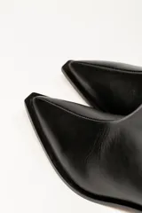 Bota corta de cuero negro con punta fina y taco bajo rectangular.