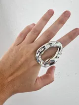 Anillo plateado de aleación con forma irregular.