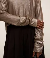 Blusa negra de punto liviano con escote redondo, manga larga y sisa raglán. Tiene una malla con lámina metálica.