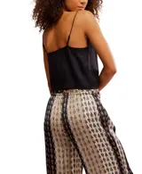 Top negro de viscosa con escote en V y tirantes finos. Presenta detalles de bordado en el escote y botones frontales que permiten abrir la prenda parcialmente.