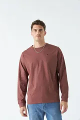 Remera gris de manga larga con cuello redondo y logo bordado en el pecho.