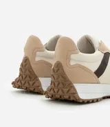 Championes de estilo jogging para mujer, confeccionados en poliuretano color tostado con recortes contrastantes en color crema. Presentan cierre de cordones blancos y suela de PVC que se extiende hasta el talón con base dentada.