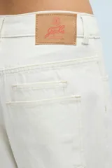 Jean blanco de denim 100% algodón, de calce relajado y pierna semi bombe. Cuenta con recortes en la entrepierna y pinzas que generan un efecto curvo. Con ruedo al corte y desflecado, doble bolsillo trasero del lado derecho, badana y avíos marcarios personalizados.