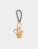 Llavero con correa de strass gris y dijes dorados: rosa, corazón y moño.