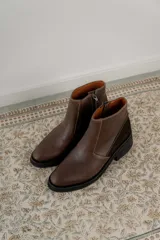 Bota corta color marrón con textura símil cuero de cocodrilo, caña baja, punta redondeada y taco cuadrado.