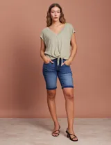 Blusa azul de modal con escote en V, abertura central con botones y ruedo anudado.