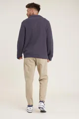 Sweater de punto color crema con cuello alto y cierre de cremallera parcial. Diseño de corte holgado y mangas largas.