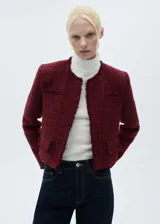 Chaqueta corta de tweed color rojo con cuello redondo, cierre frontal con botones y bolsillos de ribete.