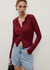 Short de jean celeste claro, de tiro alto, corte recto y largo a medio muslo. Presenta cinco bolsillos y cierre frontal con cremallera y botón.