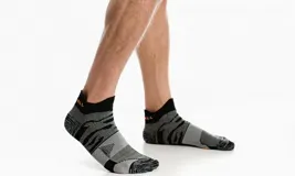 Calcetín de corte bajo para correr, con almohadillas acolchadas y malla para transpirabilidad.