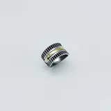 Anillo ancho en plata 925 con detalles lineales en relieve y banda central en oro.