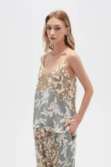 Musculosa de bretel fino con estampado floral en tonos beige, verde y blanco, corte al cuerpo y escote en V.