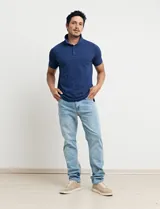 Chomba celeste con estampado de lunares blancos, cuello clásico y mangas cortas.