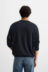 Jersey de punto azul marino de corte clásico, con cuello redondo y mangas largas.