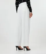 Pantalón wide leg blanco confeccionado en crepé, con botones dorados en los laterales, bolsillos y cierre con botón y cremallera.