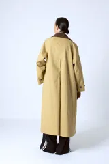 Trench color beige con cuello marrón de pana, doble botonadura y corte clásico.