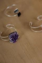 Brazalete rígido abierto de metal plateado con piedra natural amatista.