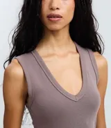 Blusa básica sin mangas color blanco, confeccionada en algodón con elastano, con escote en V y textura acanalada.