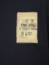 Remera gris de algodón con cuello redondo y estampado pequeño en el pecho.