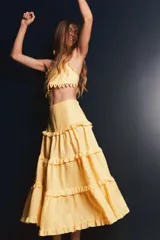 Falda larga de lino color amarillo claro con múltiples capas de volados suaves que aportan fluidez.