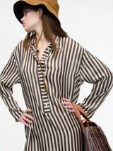 Vestido largo de manga larga con botones en el escote y tajos verticales laterales. Diseño a rayas verticales en tonos marrón y blanco.