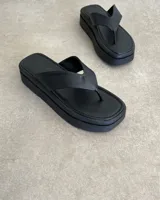 Ojotas negras con base cuadrada y tiras blancas.