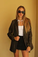 Blazer negro con rayas verticales en hilo dorado brillante, con solapas y un botón frontal.