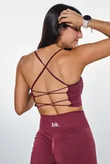 Conjunto deportivo color borgoña compuesto por un top con breteles finos y logo "bk." estampado en blanco, y un short de calce ajustado.