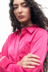 Camisa de satén fucsia con bolsillo en el pecho y diseño de manga larga.