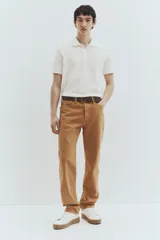 Remera polo blanca de piqué de algodón, corte regular fit, con cuello clásico, tapeta de botones, mangas cortas, remate acanalado en cuello y mangas, y bajo recto con aberturas laterales.