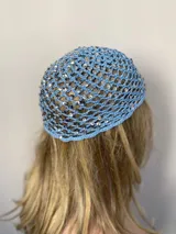 Gorro tipo mesh cap tejido a crochet en hilo color crema, con lentejuelas iridiscentes.
