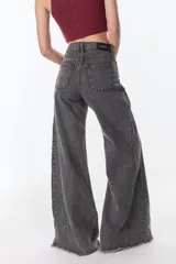 Pantalón de jean gris oscuro de corte wide leg con cintura alta y ruedo desflecado.